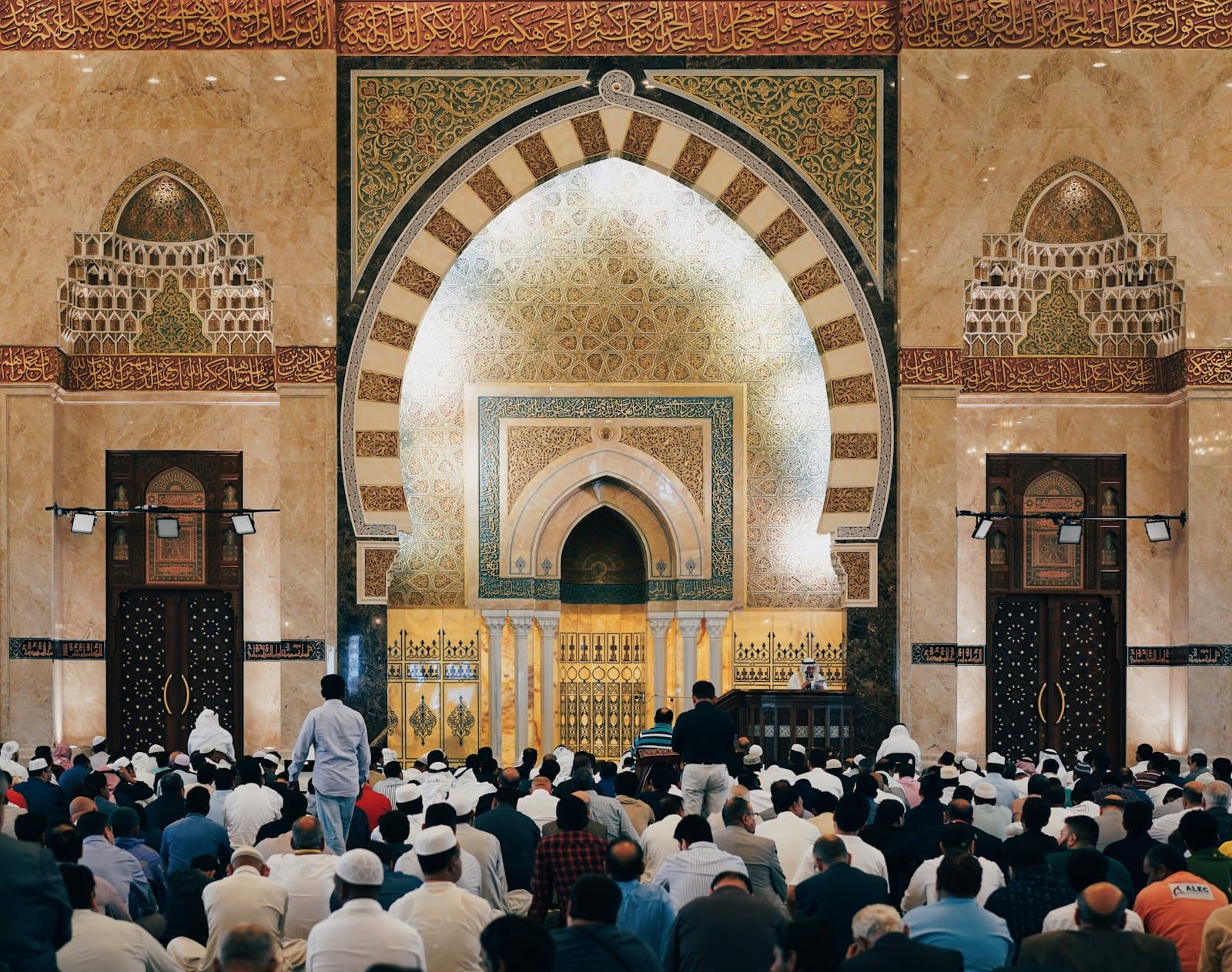 Jemaah bersolat di dalam masjid, di hadapan mihrab yang berhias ukiran emas